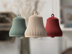 Sage Green, Neutral Beige, and Burgundy ribbed Christmas bell ornaments hanging in a holiday room
