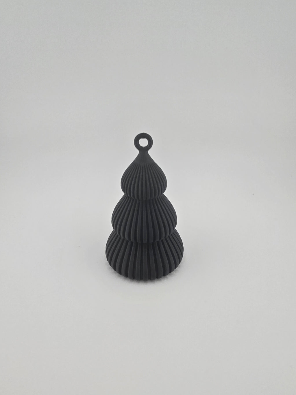 Black ribbed Christmas tree ornament on a white background